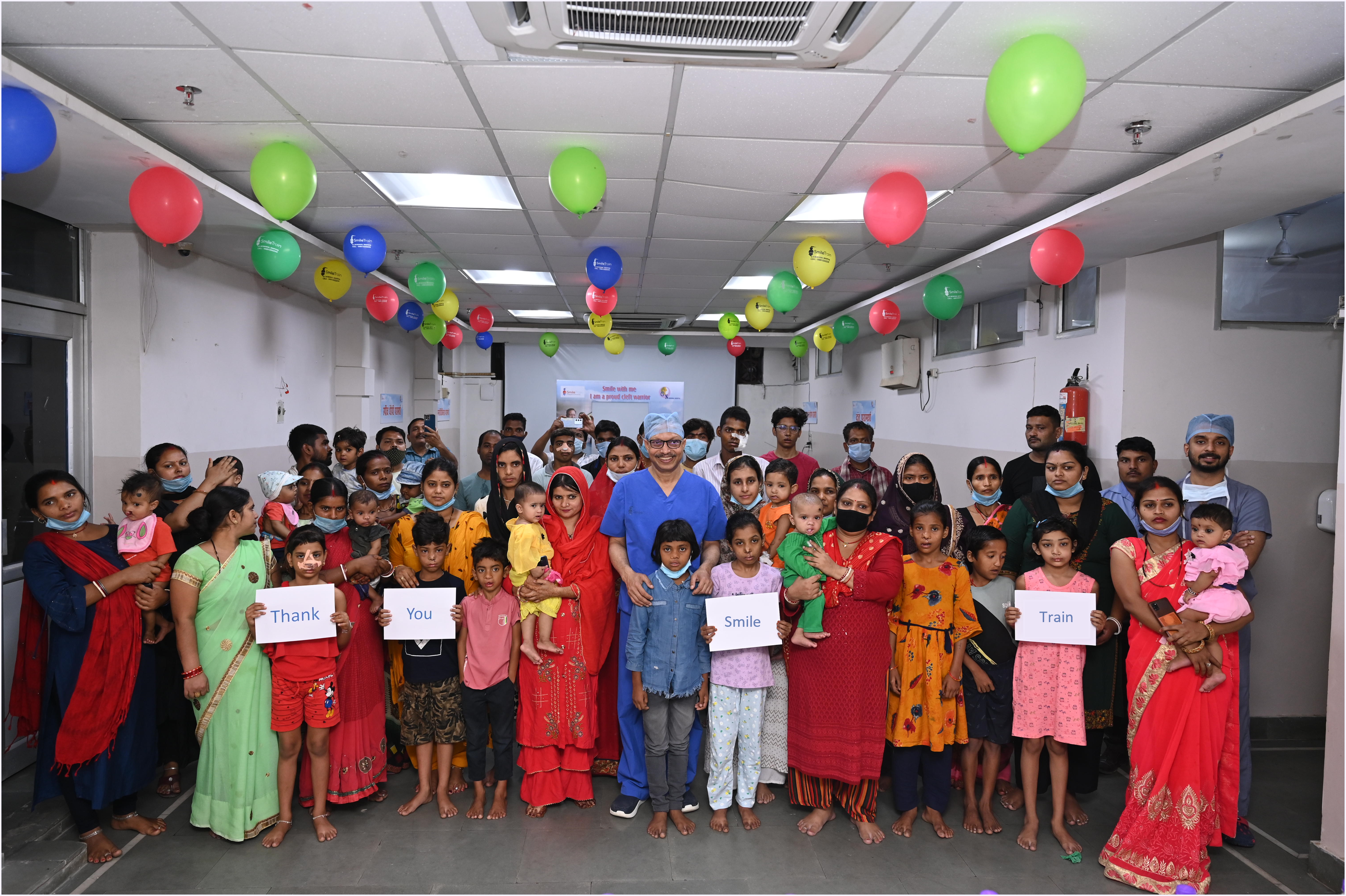 Dr Subodh smiling with his patients and holding Thank You signs
