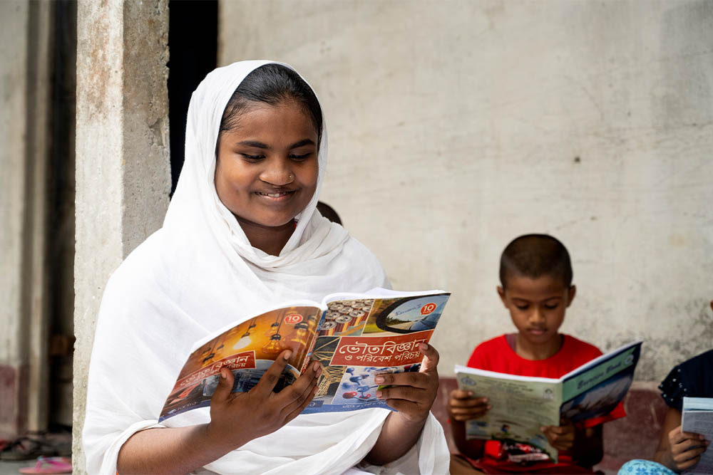 Rajiya smiling and reading a book after cleft surgery