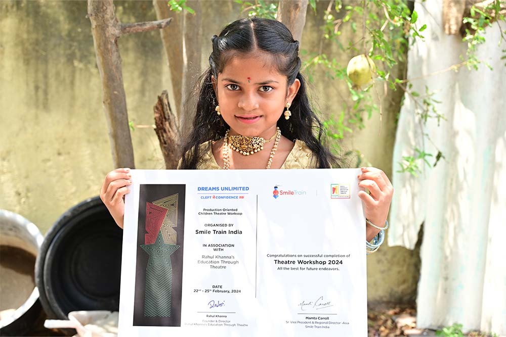 Pravallika smiling and holding certificate after cleft surgery