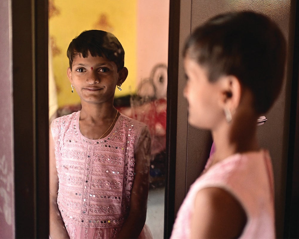 Yashoda confidently looking at her reflection in the mirror – and her newfound smile