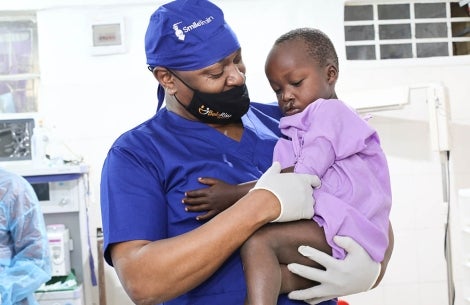 Smile Train surgeon holds patient