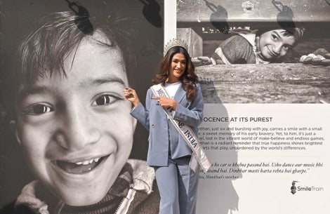 Shweta Sharda smiling and pointing to a Face to Face portrait