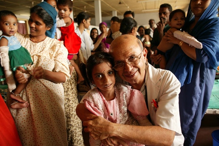 Dr. Adenwalla smiling and hugging a patient