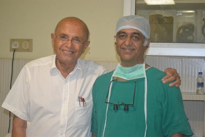 Dr Hirji Adenwalla smiling with a surgeon