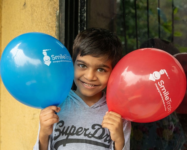 Samrat smiling and holding balloons