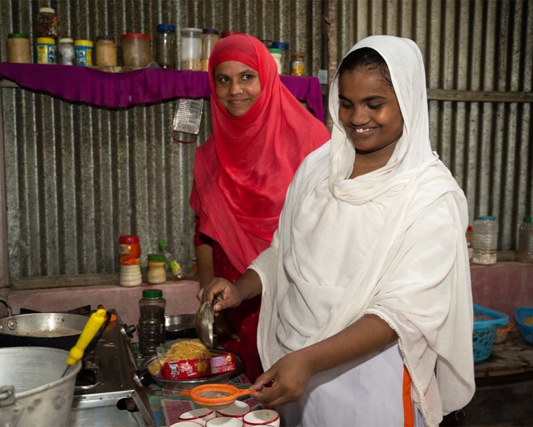 Rajiya smiling and cooking with her mother after cleft surgery