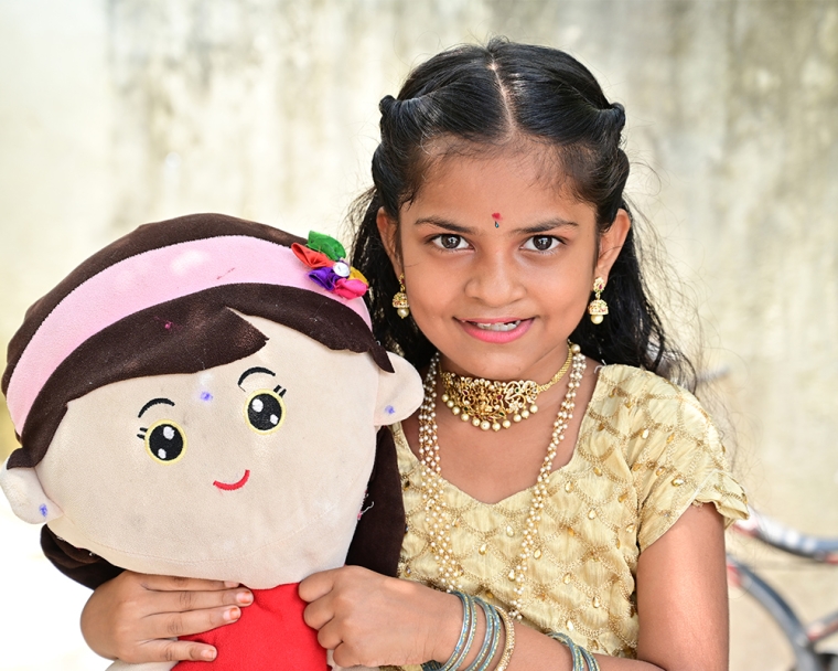 Pravallika smiling with a doll after cleft surgery